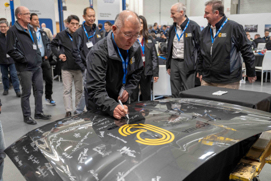 정의선 현대자동차그룹 회장이 지난 10일(현지시각) 미국 캘리포니아 캘리포니아시티에 위치한 모하비주행시험장에서 열린 설립 20주년 기념행사에서 참석자들과 함께 기념 사인을 하고 있다. 현대차그룹 제공